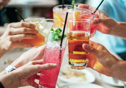 group of hands with alcohol drinks cheers in middle