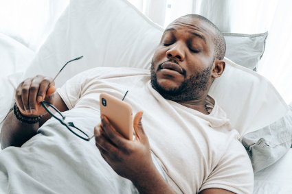 man with ptsd on phone can't sleep