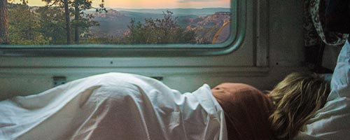 woman laying on her side in an RV overlooking mountains