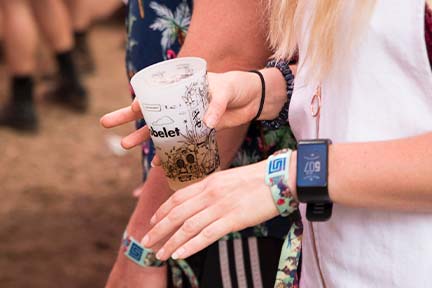 hands of music festival attendee with cup in hand