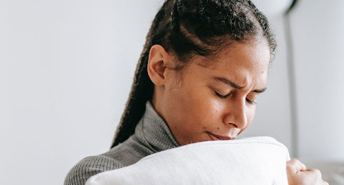 woman clenching pillow upset with insomnia from ptsd