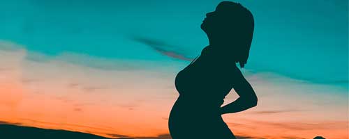 A pregnant woman uses SleepPhones headphones for hypnobirthing meditation