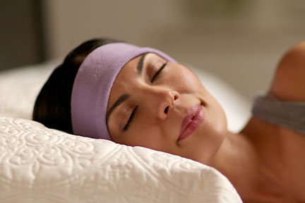 woman sleeping on side with lavender SleepPhones wireless sleep headphones
