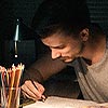 person working at desk in the dark with work light