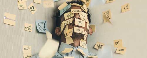 A distressed man covered in sticky notes is seeking productivity tips.
