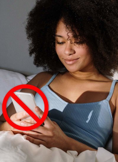 woman uses on phone at night while in bed, red X over phone