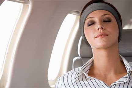 woman wearing sleepphones to relax on a plane
