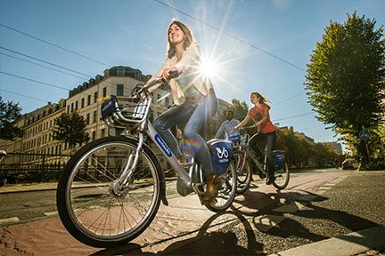 people riding bikes in a city on sunny day