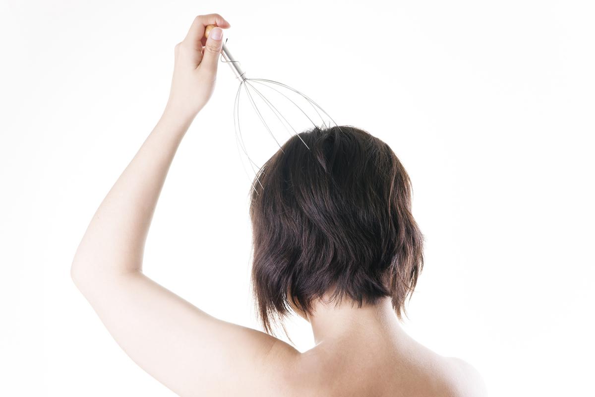 Photo of woman using thin scalp massager in article about Autonomous Sensory Meridian Response (ASMR) for sleeping