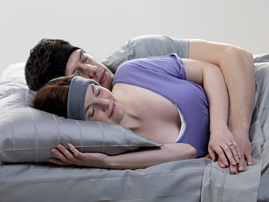 couple sleeping in bed with SleepPhones on