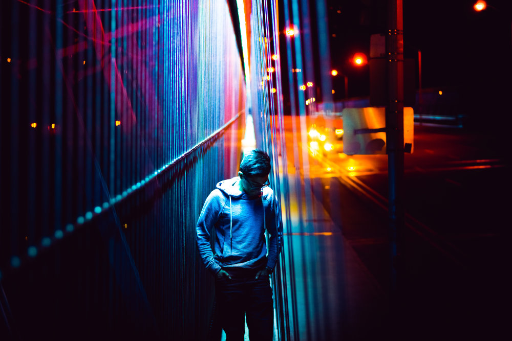 man wearing hoodie walking in a city