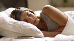 woman sleeping comfortable in sleepphones classic headphones connected to a smartphone